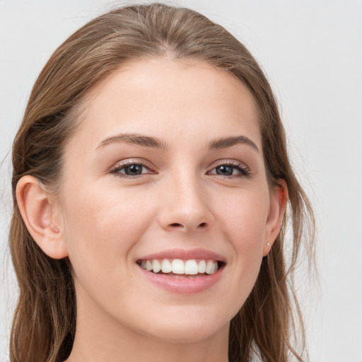 Joyful white young-adult female with long  brown hair and grey eyes