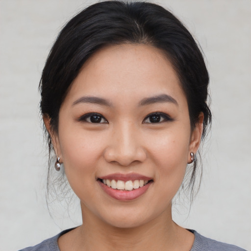 Joyful asian young-adult female with medium  brown hair and brown eyes