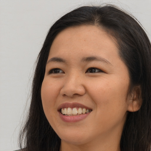 Joyful asian young-adult female with long  brown hair and brown eyes