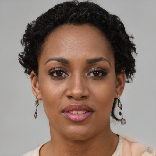 Joyful black young-adult female with short  brown hair and brown eyes