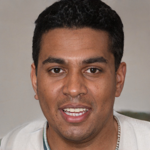 Joyful black young-adult male with short  black hair and brown eyes