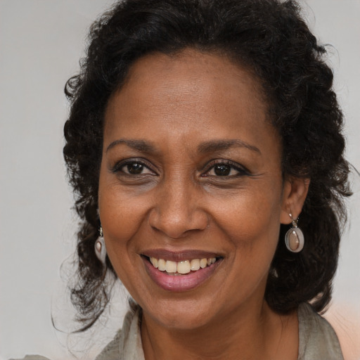 Joyful black adult female with long  brown hair and brown eyes
