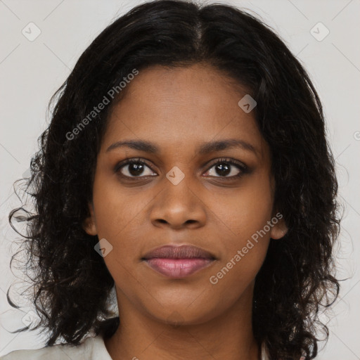 Joyful black young-adult female with long  brown hair and brown eyes