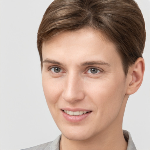 Joyful white young-adult female with short  brown hair and grey eyes