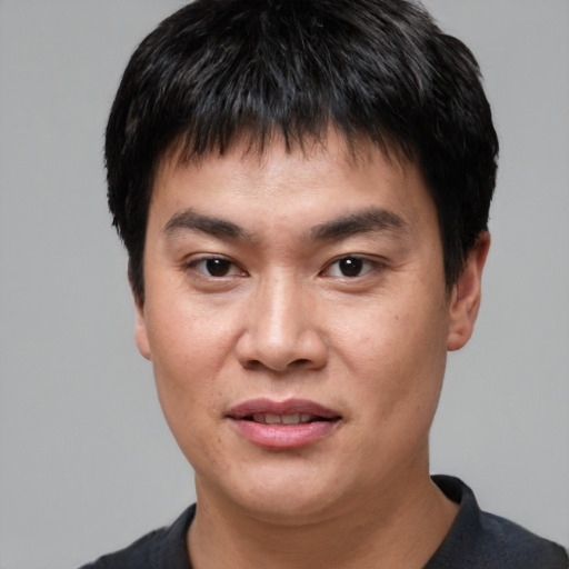 Joyful asian young-adult male with short  black hair and brown eyes
