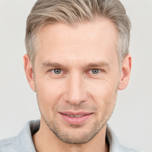 Joyful white adult male with short  brown hair and grey eyes