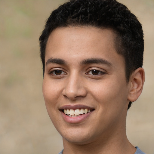 Joyful latino young-adult male with short  brown hair and brown eyes