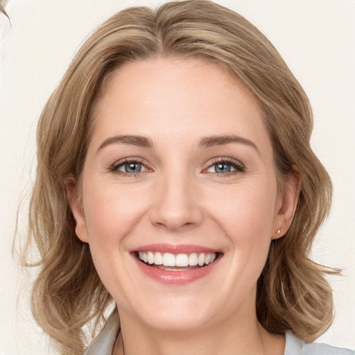 Joyful white young-adult female with long  brown hair and blue eyes