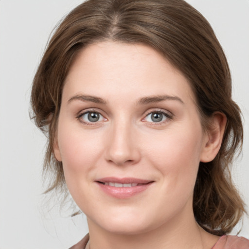 Joyful white young-adult female with medium  brown hair and grey eyes