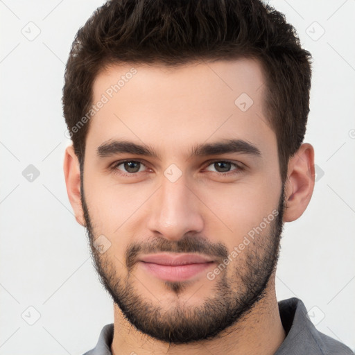 Joyful white young-adult male with short  brown hair and brown eyes