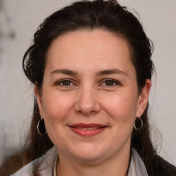 Joyful white adult female with medium  brown hair and brown eyes