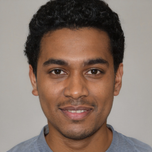 Joyful black young-adult male with short  black hair and brown eyes