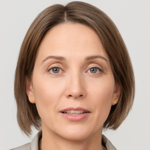 Joyful white adult female with medium  brown hair and grey eyes