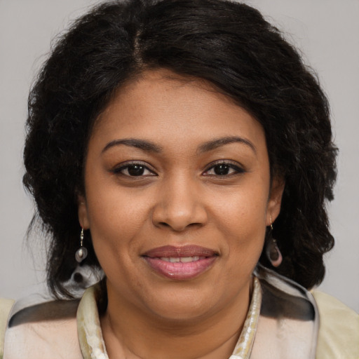 Joyful black young-adult female with long  brown hair and brown eyes