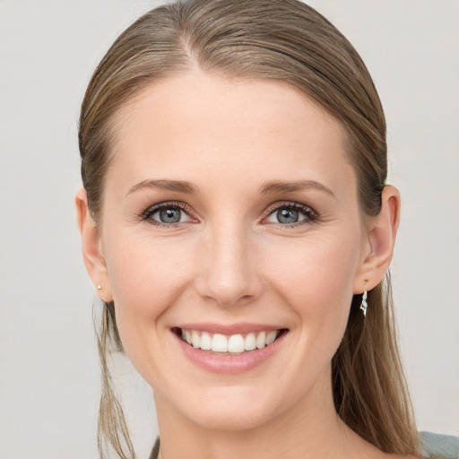 Joyful white young-adult female with medium  brown hair and grey eyes