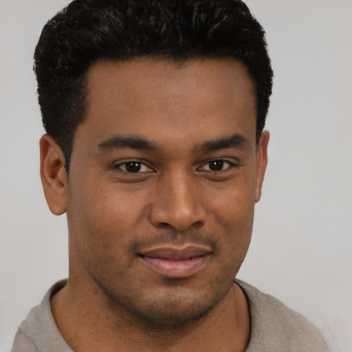 Joyful latino young-adult male with short  brown hair and brown eyes