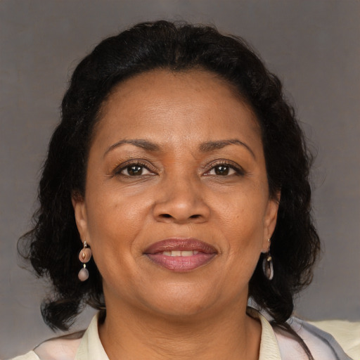 Joyful black adult female with medium  brown hair and brown eyes