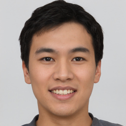 Joyful asian young-adult male with short  black hair and brown eyes