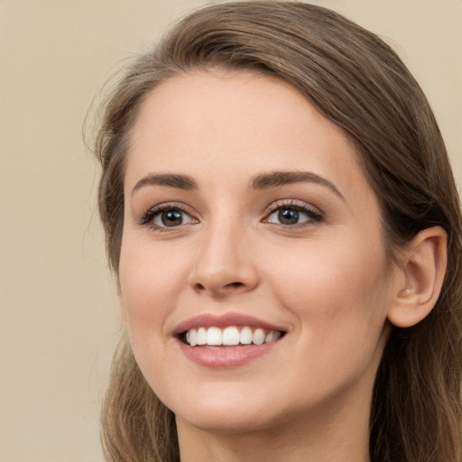 Joyful white young-adult female with long  brown hair and green eyes