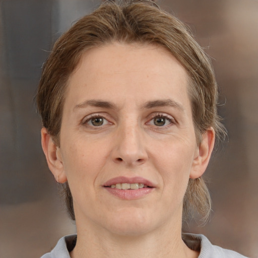 Joyful white adult female with medium  brown hair and grey eyes