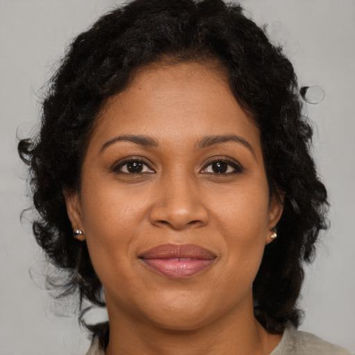 Joyful black adult female with medium  brown hair and brown eyes