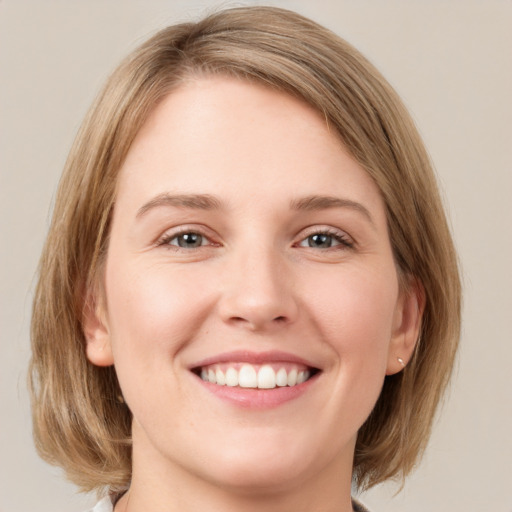 Joyful white young-adult female with medium  brown hair and green eyes