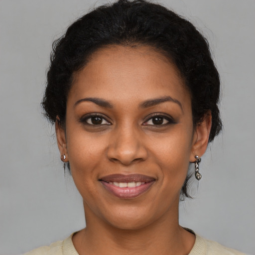 Joyful black young-adult female with short  black hair and brown eyes