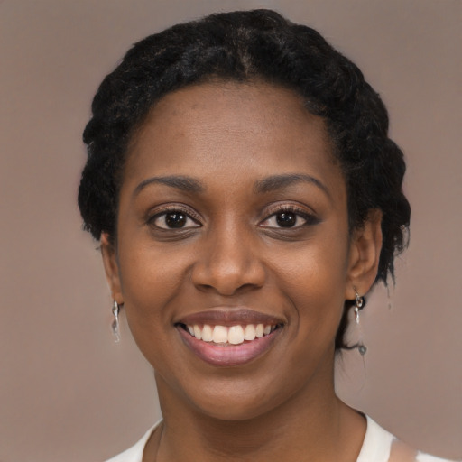 Joyful black young-adult female with short  black hair and brown eyes