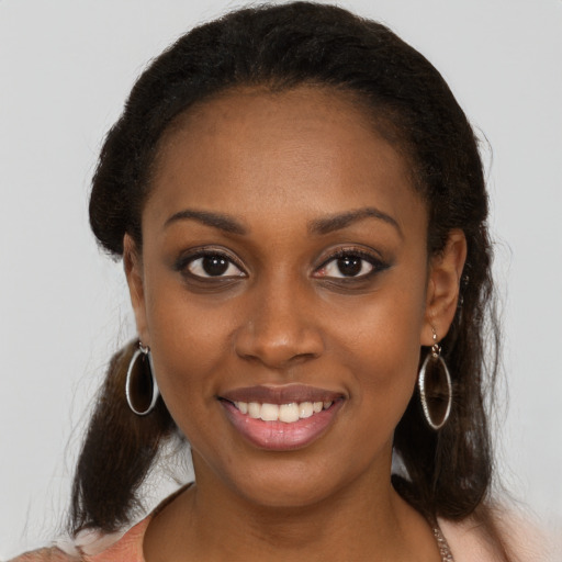 Joyful black young-adult female with long  brown hair and brown eyes