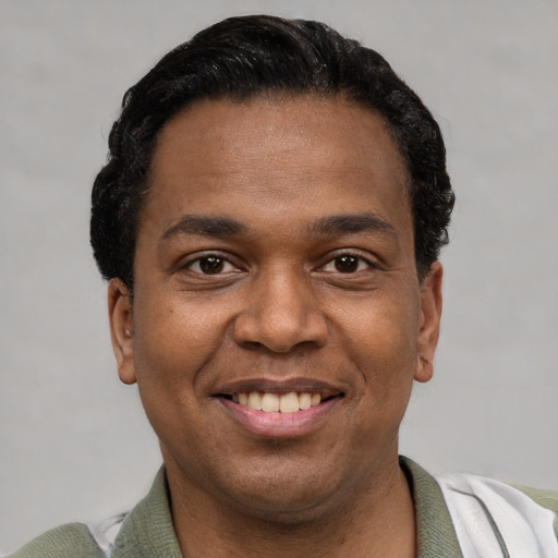 Joyful latino young-adult male with short  black hair and brown eyes