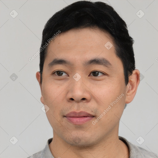 Joyful asian young-adult male with short  black hair and brown eyes