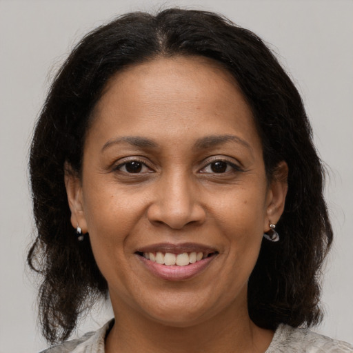 Joyful black adult female with medium  brown hair and brown eyes