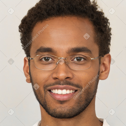 Joyful black young-adult male with short  brown hair and brown eyes