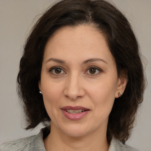 Joyful white adult female with medium  brown hair and brown eyes