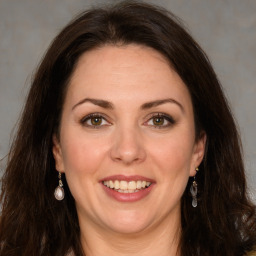 Joyful white adult female with long  brown hair and brown eyes