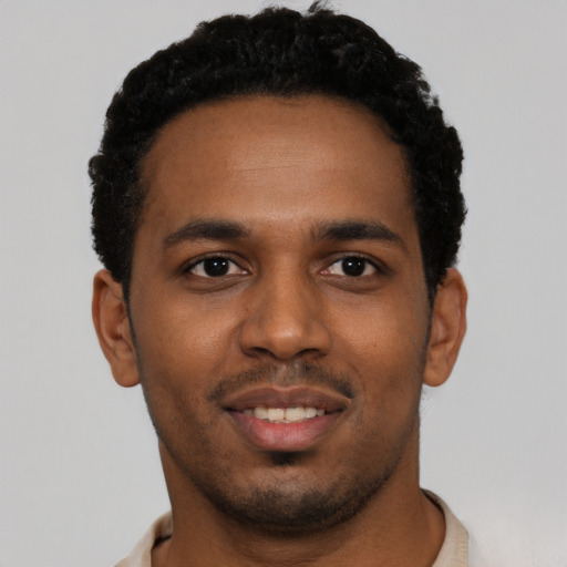 Joyful black young-adult male with short  black hair and brown eyes