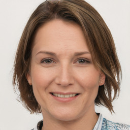 Joyful white adult female with medium  brown hair and grey eyes