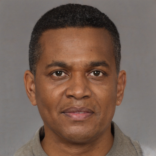 Joyful black adult male with short  brown hair and brown eyes