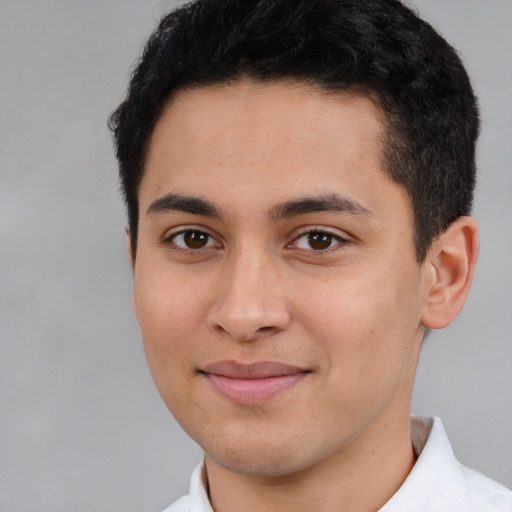 Joyful latino young-adult male with short  brown hair and brown eyes