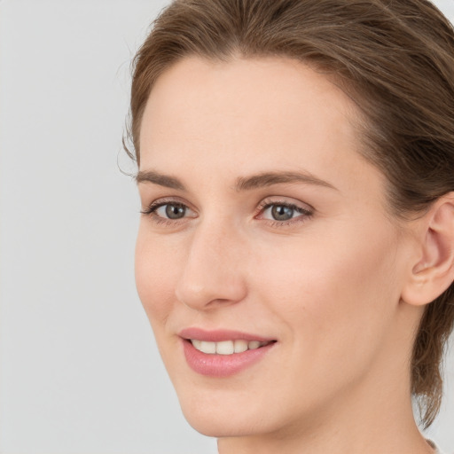 Joyful white young-adult female with long  brown hair and grey eyes