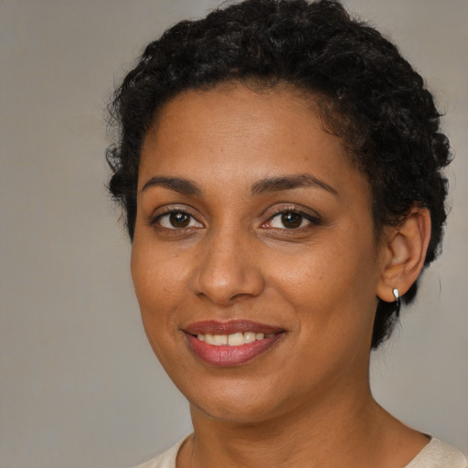 Joyful black young-adult female with short  brown hair and brown eyes