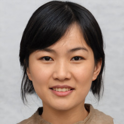 Joyful asian young-adult female with medium  black hair and brown eyes