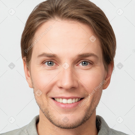 Joyful white young-adult male with short  brown hair and grey eyes