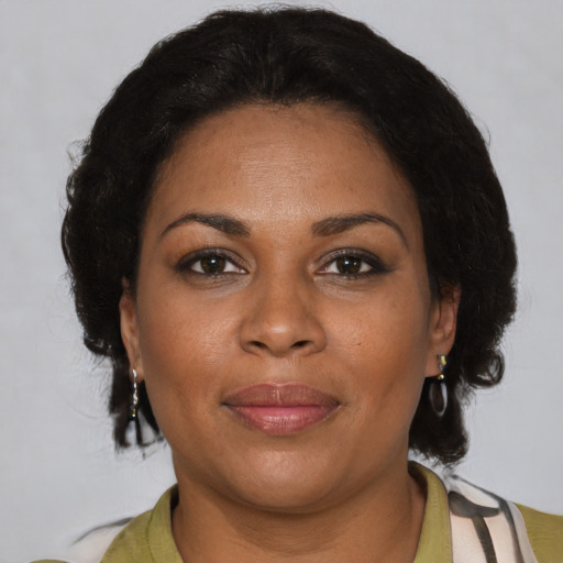 Joyful black adult female with short  brown hair and brown eyes