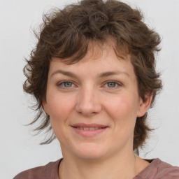 Joyful white young-adult female with medium  brown hair and blue eyes