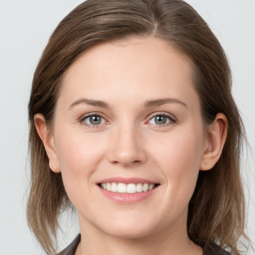 Joyful white young-adult female with medium  brown hair and grey eyes