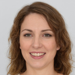 Joyful white young-adult female with long  brown hair and green eyes