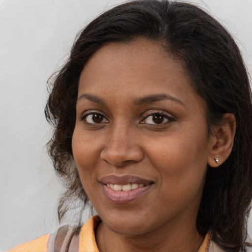 Joyful black young-adult female with medium  brown hair and brown eyes