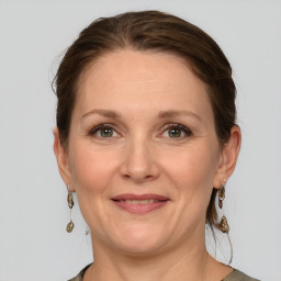 Joyful white adult female with medium  brown hair and grey eyes