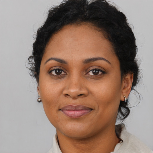 Joyful black adult female with medium  brown hair and brown eyes